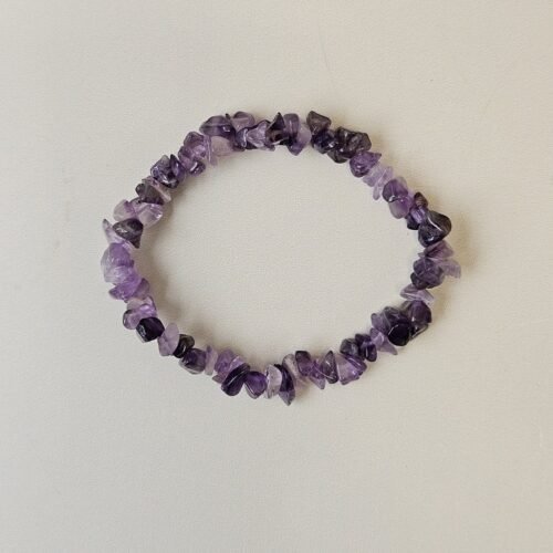 Amethyst crystal bracelet with polished purple chips on a cream background