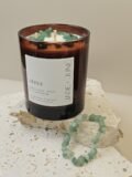 Green Aventurine crystal bracelet beside the Ceres candle on travertine, Green Aventurine chips set in the wax