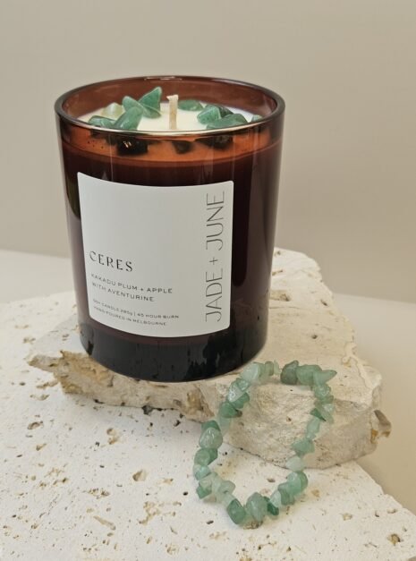 green-aventurine-bracelet-02 Green Aventurine crystal bracelet beside the Ceres candle on travertine, Green Aventurine chips set in the wax
