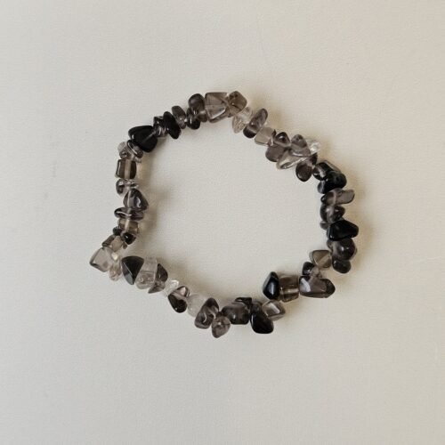 Smoky Quartz crystal bracelet with polished grey chips on a cream background