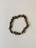 Tiger's Eye crystal bracelet with polished gold and brown chips on a cream background