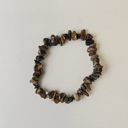 Tiger's Eye crystal bracelet with polished gold and brown chips on a cream background