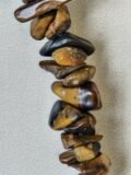 Close view of the polished Tiger's Eye chips on the bracelet