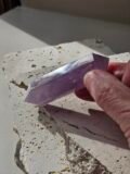 Amethyst double terminated point held in the hand to show its size
