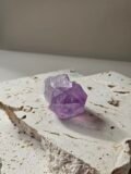 Rough Amethyst point on a pale stone slab