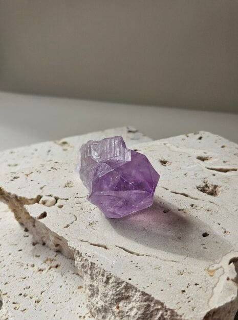 Rough Amethyst point on a pale stone slab