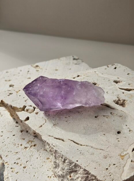 Amethyst Rough Point 2 Rough Amethyst point on a pale stone slab, rotated to another angle