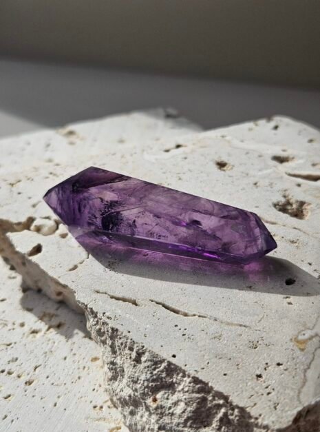 Amethyst wand 1 Deep purple double-terminated Amethyst wand on a pale stone slab
