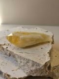Bahia Citrine point on a cream surface, front facing