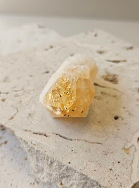 Citrine point 1 Small Citrine point on a cream surface, front facing