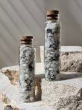Two vials of Rainbow Moonstone chips standing close together, showing the chips through the glass