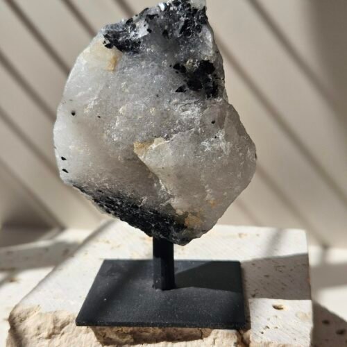 Rough Rainbow Moonstone on its stand, turned to a three quarter angle