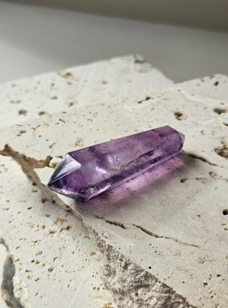 amethyst wand 5 Deep purple double-terminated Amethyst wand on a pale stone slab in natural light